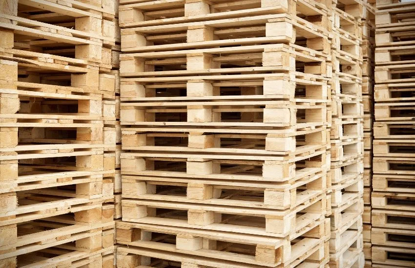 Almacenamiento de palets de madera apilados en un almacén industrial